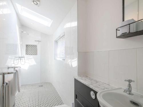 a white bathroom with a sink and a bath tub at 2 Bed in Holt 78233 in Cley next the Sea