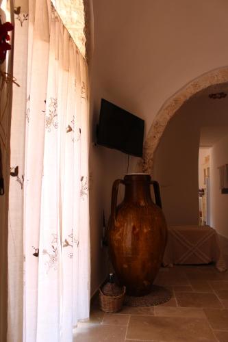 Un jarrón grande sentado en una habitación con ventana en Trullo Il Melograno, en Ostuni