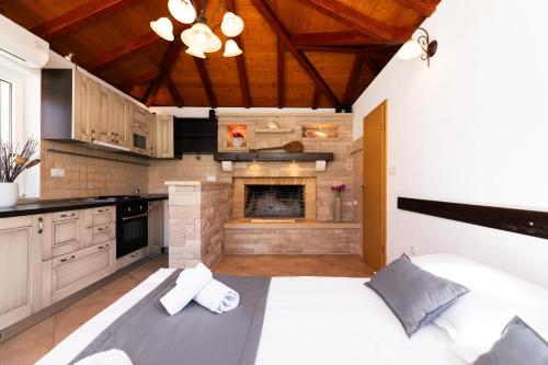a large kitchen with a bed and a fireplace at VILLA AGAPE - Three bedroom villa on 15k m2 olive grove - Incredible 360 view - Free parking - Private pool and jacuzzi in Mirce