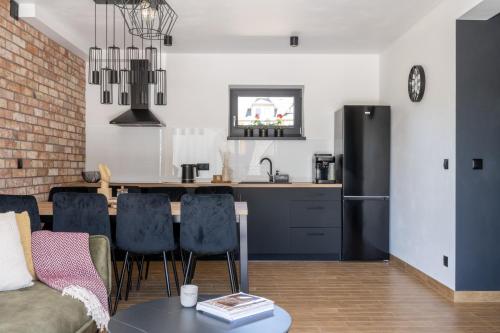 a kitchen and living room with a black refrigerator at Aparteo Domek na 102 - Jeleń i Loft in Kościelisko