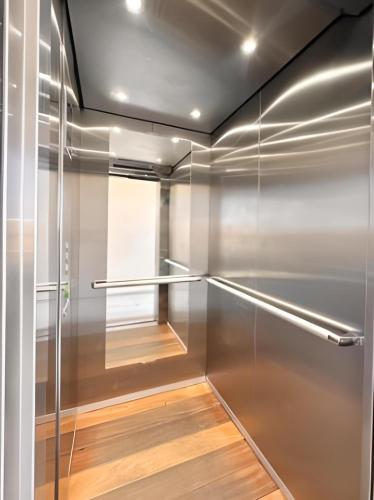 a walk in closet with stainless steel walls and wood floor at Levitat 32 in Playa del Carmen