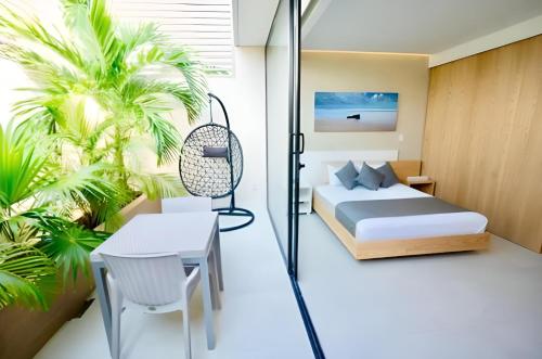 a bedroom with a bed and a table and a chair at Levitat 32 in Playa del Carmen