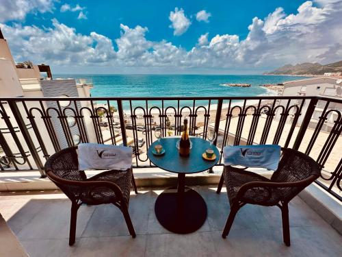 a balcony with a table and chairs and the ocean at Vienna Luxury Apartments in Dobra Voda