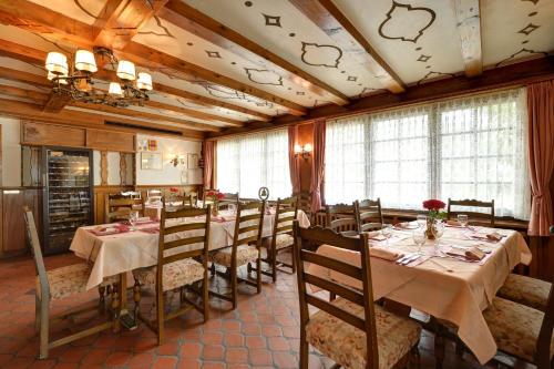 a restaurant with tables and chairs in a room at Hôtel du Chasseur in Enges