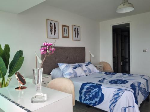 a bedroom with a blue and white bed and a table at Antofagasta Mistico-SOLO ADULTOS in Antofagasta
