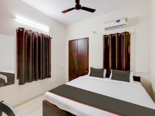 um quarto com uma cama e uma ventoinha de tecto em OYO Flagship Valasaravakkam em Chennai