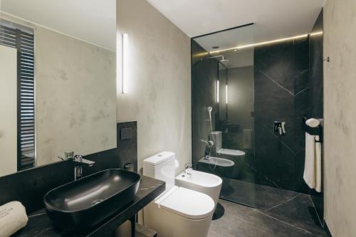 a bathroom with a black sink and a toilet at Grand Brizo Bel Air in Buenos Aires