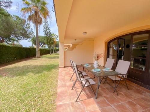 un patio con una mesa, sillas y una palmera en Great Duplex Apartment in Marbesa, en Marbella