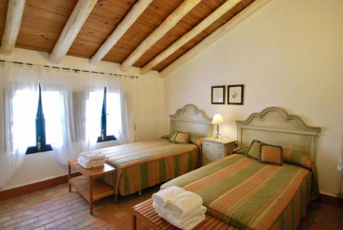 - une chambre avec 2 lits et une fenêtre dans l'établissement Finca La Vicaria AGUADULCE, à Zufre