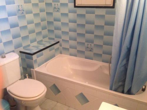 La salle de bains est pourvue de toilettes, d'une baignoire et de toilettes. dans l'établissement APPARTEMENT de 50m2 en rez de jardin - 3 étoiles, à Porto-Vecchio