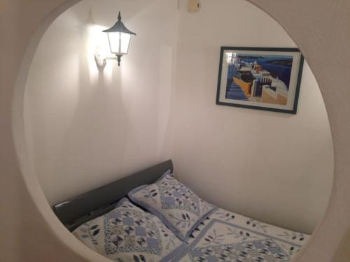 - une chambre avec un lit, une lampe et un miroir dans l'établissement APPARTEMENT de 50m2 en rez de jardin - 3 étoiles, à Porto-Vecchio