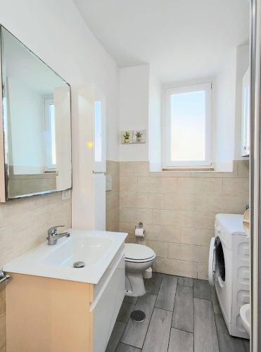a white bathroom with a sink and a toilet at Aria di Borgo in Nettuno