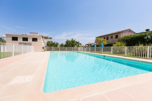 une piscine avec de l'eau bleue dans une maison dans l'établissement Antibes Rez de Jardin, grande terrasse dans résidence avec piscine, à Antibes