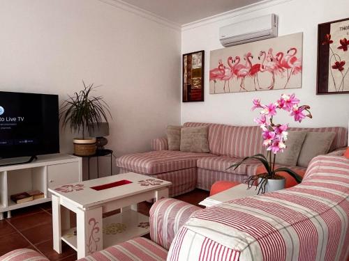 a living room with a couch and a tv at Santa luzia Tavira 5min walk to Praia do Barril in Tavira