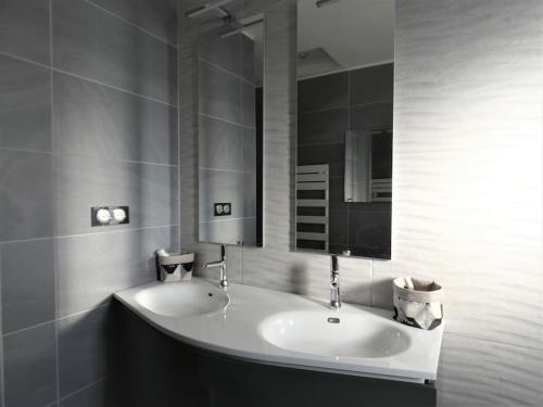 une salle de bain avec un lavabo et un miroir dans l'établissement Maison TOMASELLO, à Carcassonne