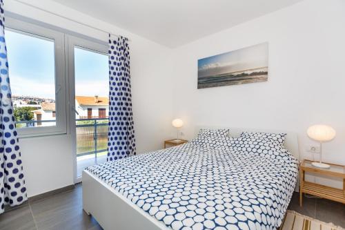 Lavender, Lighthouse, Sunrise Apartments - Kuća&More House No13 في كرك: غرفة نوم بيضاء مع سرير ونافذة