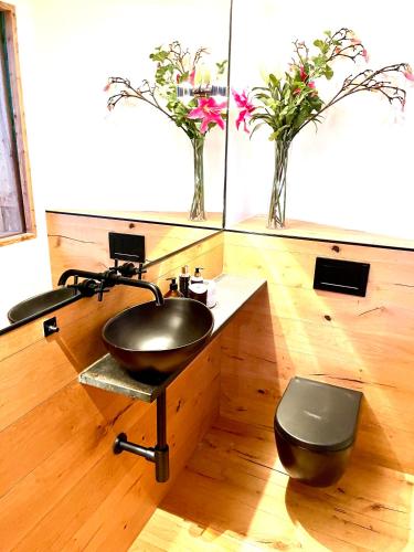 a bathroom with a black sink and a toilet at stylische Alpenlounge mit Pool, Sauna und Jacuzzi, für bis zu 22 Personen in Bayrischzell