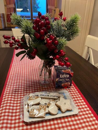 a table with a vase of christmas cookies and a vase of flowers at Chalupa na Leskové in Velké Karlovice