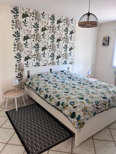 a bedroom with a bed with a quilt on it at Les Gîtes de Yanaely - L'Ibie in Juignac