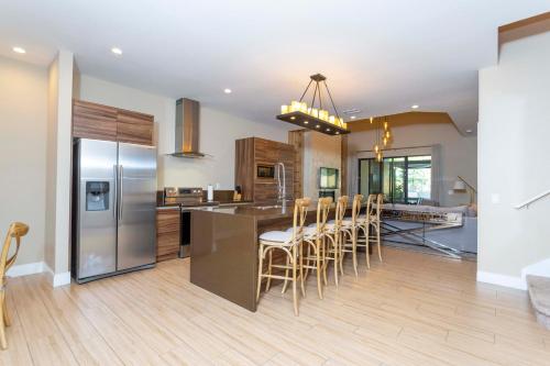 a kitchen with a refrigerator and a table with chairs at Modern and Luxury 4 suites Villa near Disney 7521 in Orlando