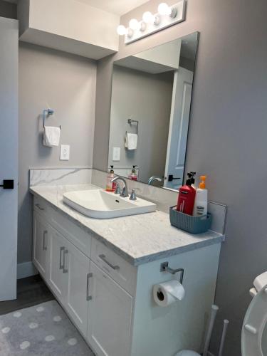 ein Bad mit einem Waschbecken und einem Spiegel in der Unterkunft Dugg Bed And Breakfast in Victoria