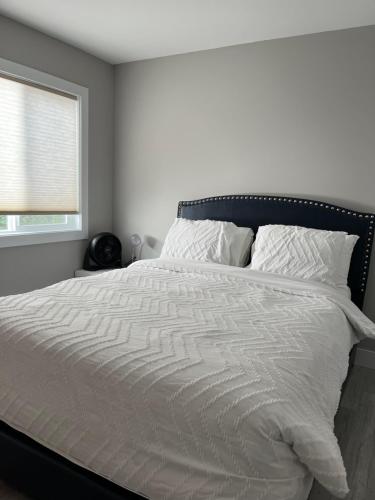 1 cama blanca en un dormitorio con ventana en Dugg Bed And Breakfast en Victoria