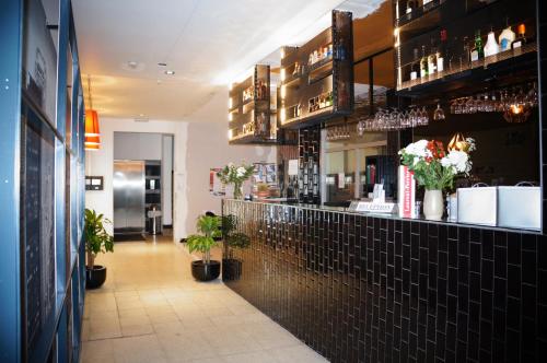 un bar dans un restaurant avec des fleurs au comptoir dans l'établissement Escale Hotel, à Bruxelles