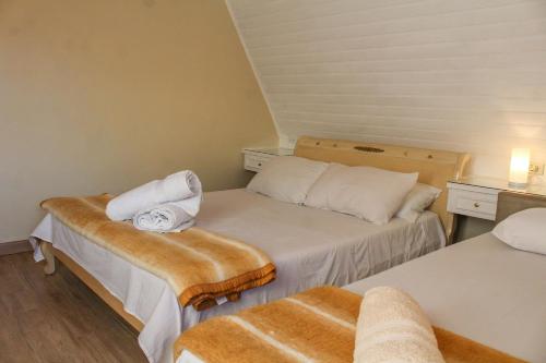 a small room with two beds with towels on them at Apartamento parque capivari no centro de capivari in Campos do Jordão