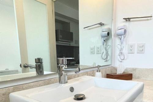 a bathroom with a white sink and a mirror at Moderno departamento en centro histórico in Mexico City