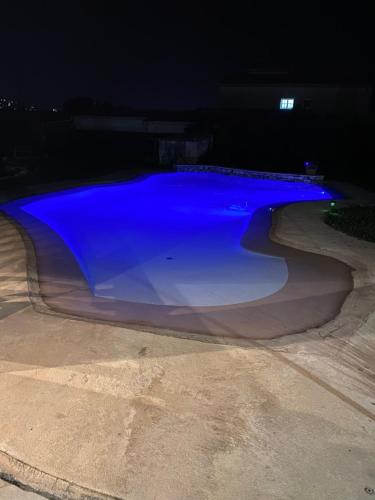 une piscine d'eau bleue la nuit dans l'établissement Appartement dans maison familiale, à Saint-Laurent-du-Var