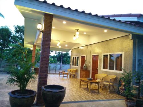 a house with a patio with chairs and a table at Pottery Street House in Sukhothai