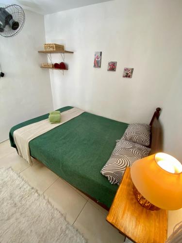 a bedroom with a bed and a table with a lamp at Apartamento no centro para Casal in Mata de Sao Joao