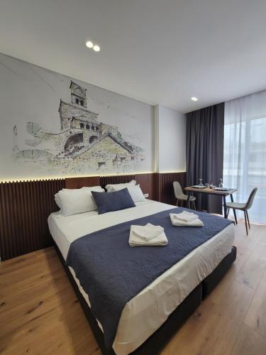 een slaapkamer met een groot bed en een tafel bij Jani Studio Apartments in Gjirokastër