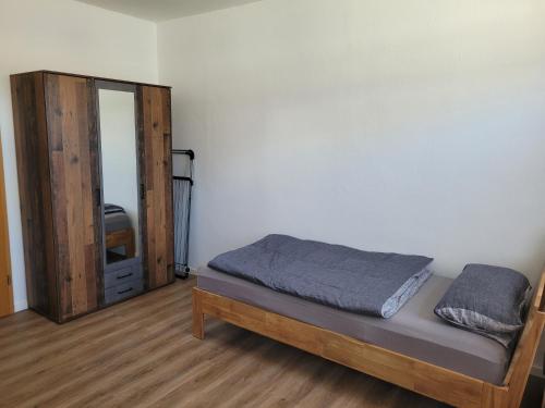 Un dormitorio pequeño con una cama y un espejo. en Monteurswohnung Roßwein - Zentral - Küche, en Roßwein