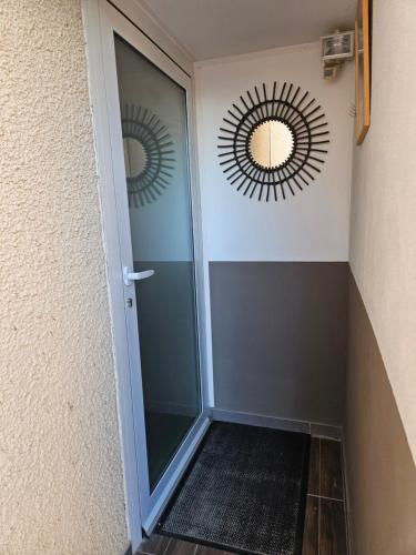 un couloir avec une porte avec deux miroirs sur le mur dans l'établissement entre mer et montagne, à Saint-Estève