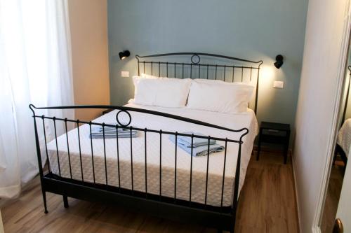 a black bed with white pillows in a bedroom at La Stella di Via Venezia in Marina di Carrara