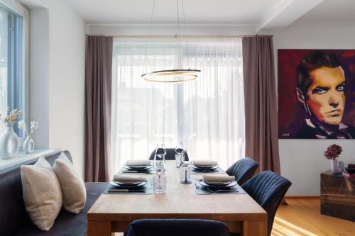 a dining room with a table with chairs and a painting at Platschberg Urban Hideaway - Stilvolles Ferienhaus mit Pool an der Weinstraße in Berghausen