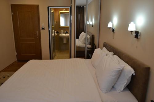 a bedroom with a large bed with white sheets and pillows at Hotel Super 8 in Skopje