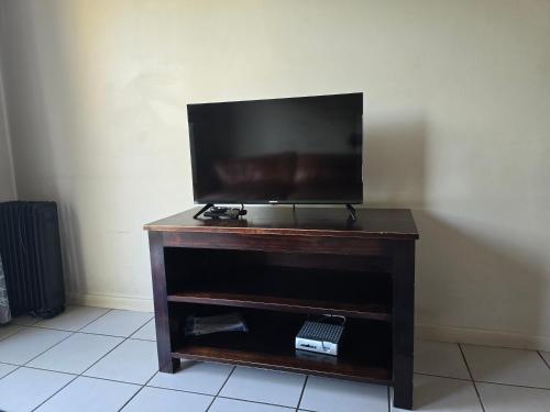 a flat screen tv sitting on top of a wooden stand at Three Flags in Pietermaritzburg