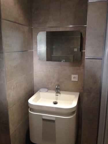 une salle de bain avec un lavabo blanc et un miroir dans l'établissement STUDIO de STANDING avec VUE MER, PISCINE, WIFI, à Porto-Vecchio