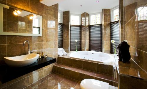 a large bathroom with a tub and a sink at Applegarth Villa Hotel & Restaurant (Adult Only) in Windermere