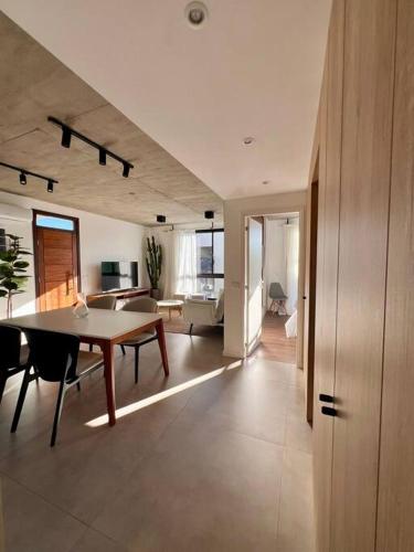 a living room with a table and a couch at Moderno apartamento en Carmelo in Carmelo