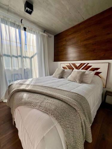 a bedroom with a large bed with a large window at Moderno apartamento en Carmelo in Carmelo