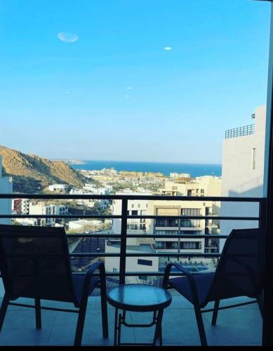a view of a balcony with chairs and a table at Oceanview Condo / Rooftop pool in Cabo San Lucas