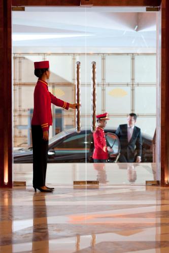 a man in uniform standing in front of a window at Mandarin Oriental, Jakarta in Jakarta