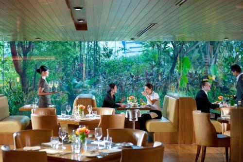 a group of people sitting at tables in a restaurant at Mandarin Oriental, Jakarta in Jakarta