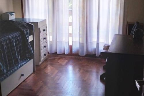 1 dormitorio con 1 cama, vestidor y cortinas en Chalet Angel de las Sierras, en Sierra de los Padres