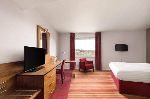 a hotel room with a bed and a flat screen tv at Holiday Inn Norwich City by IHG in Norwich