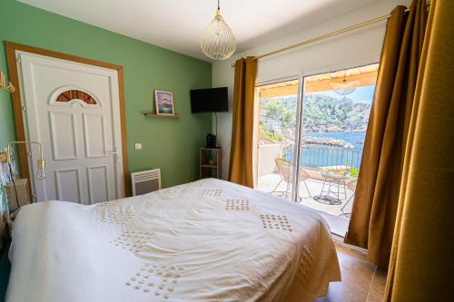 - une chambre avec un lit et une vue sur un balcon dans l'établissement Le Cabanon - Les pieds dans l'eau - Calanques - Wifi, à Ensuès-la-Redonne