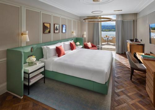 una grande camera da letto con un grande letto e una scrivania di Mandarin Oriental Palace, Luzern a Lucerna